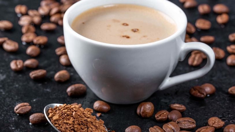 image of roasted coffee beans, ground coffee and a cup of hot coffee