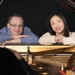 Piano duo Stephanie & Saar looking through back of piano, photo by Masataka Suemitsu