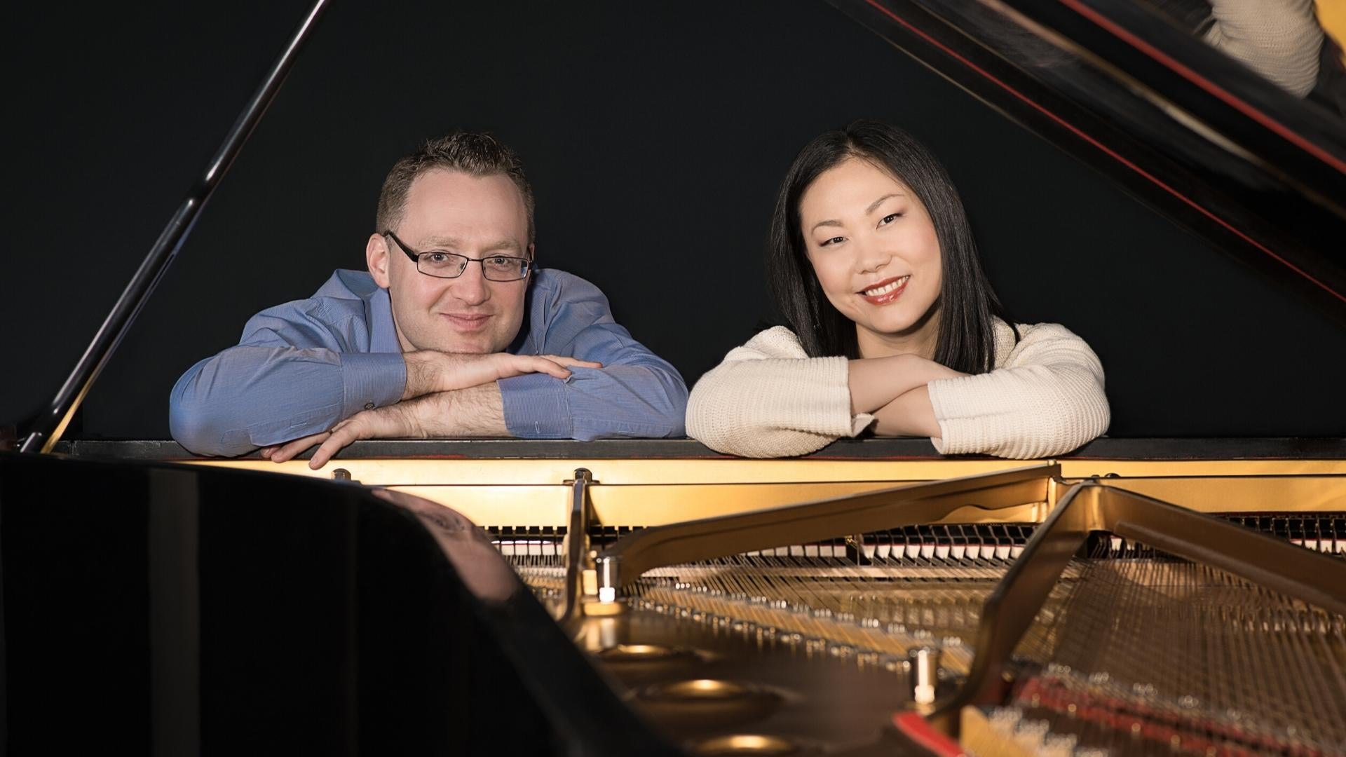 Piano duo Stephanie & Saar looking through back of piano, photo by Masataka Suemitsu