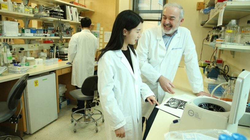 photo of Adrian Krainer in his lab with Qian Zhang