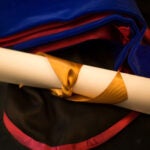 photo of graduate school diploma and gown