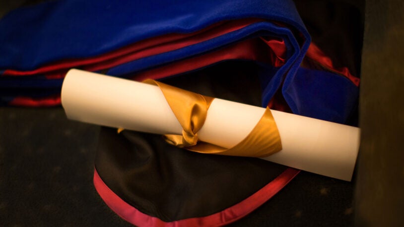 photo of graduate school diploma and gown