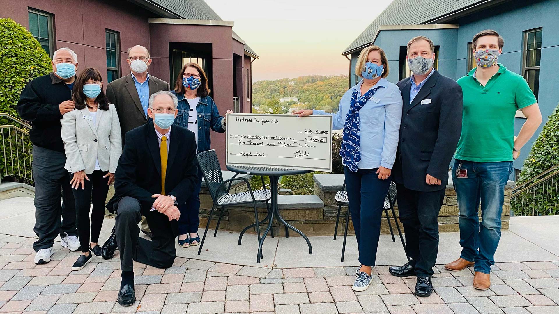 photo of members of the Masthead Cove Yacht Club presenting a check to CSHL