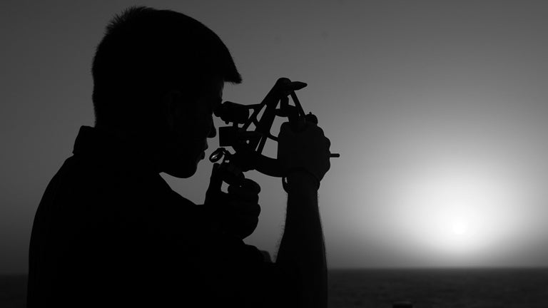 photo of a man holding a sextant