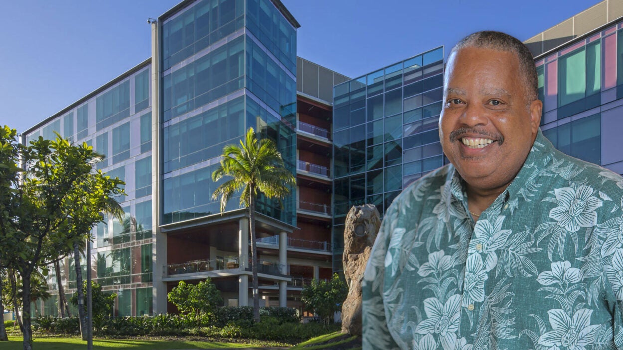 photo of Kevin Cassel in front of the University of Hawaii Cancer Center building