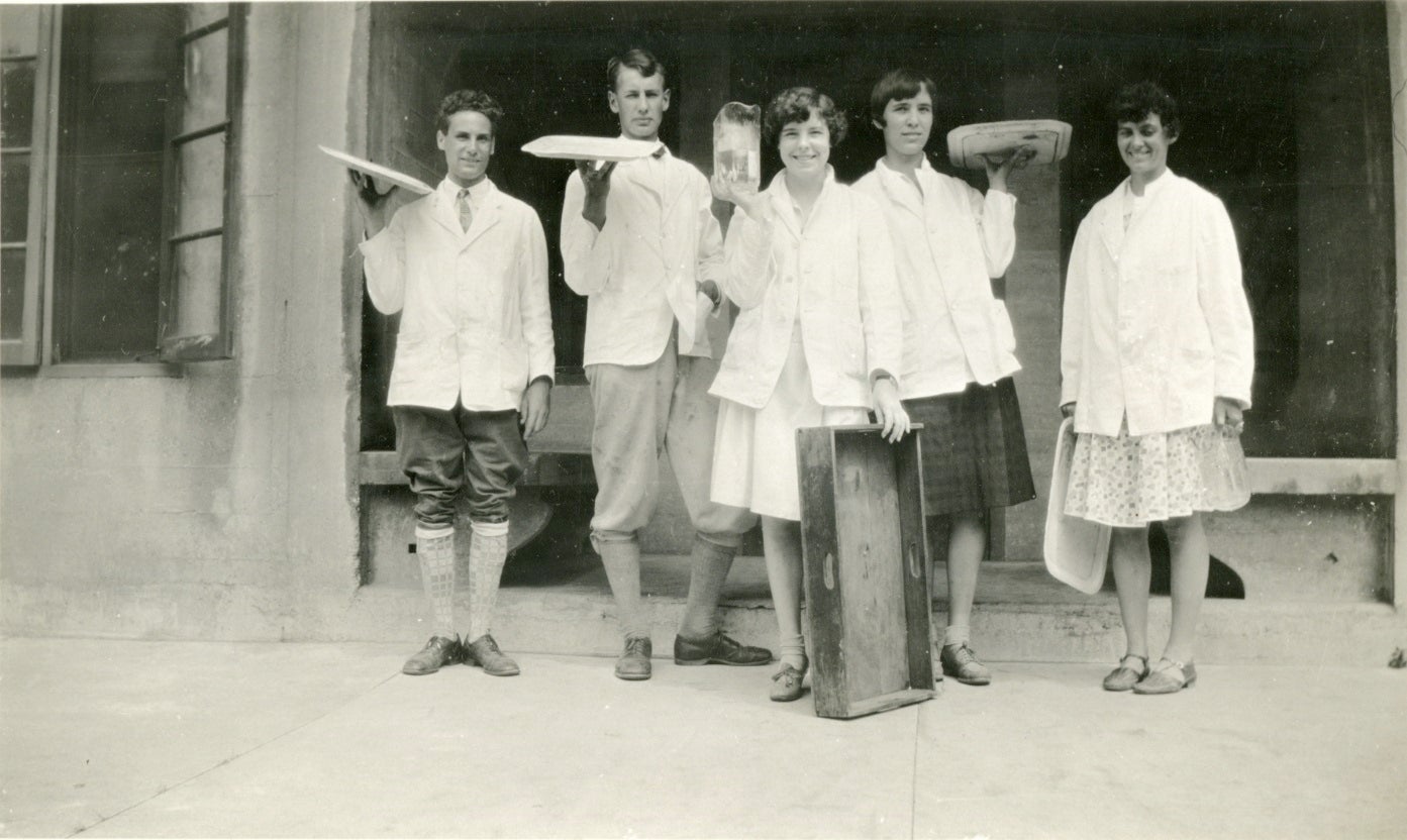 student waiters holding up trays