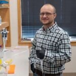 photo of Lucas Cheadle in a lab holding a pipette