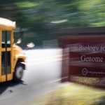 photo of a school bus passing the CSHL sign