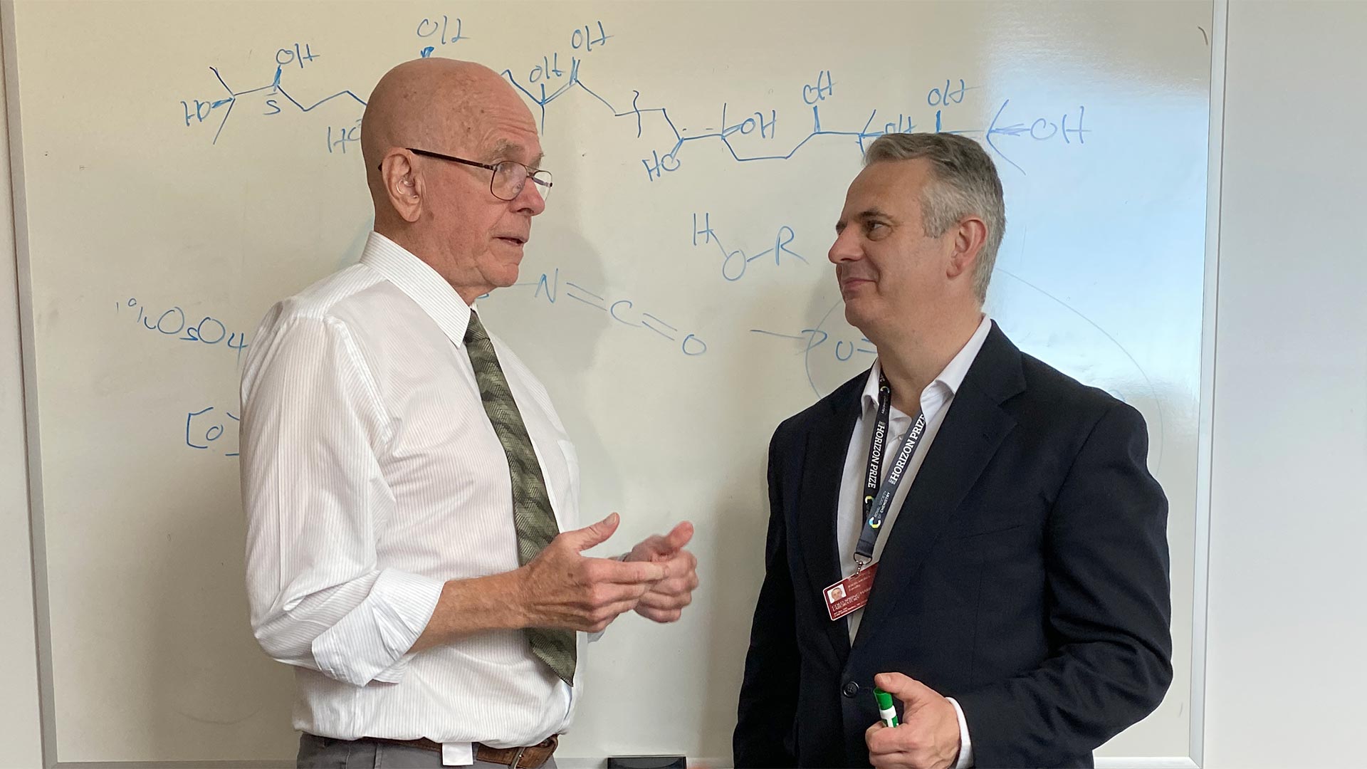 photo of Barry Sharpless and John Moses in front of a white board