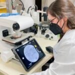 photo of Martyna Sroka looking at cells in a microscope