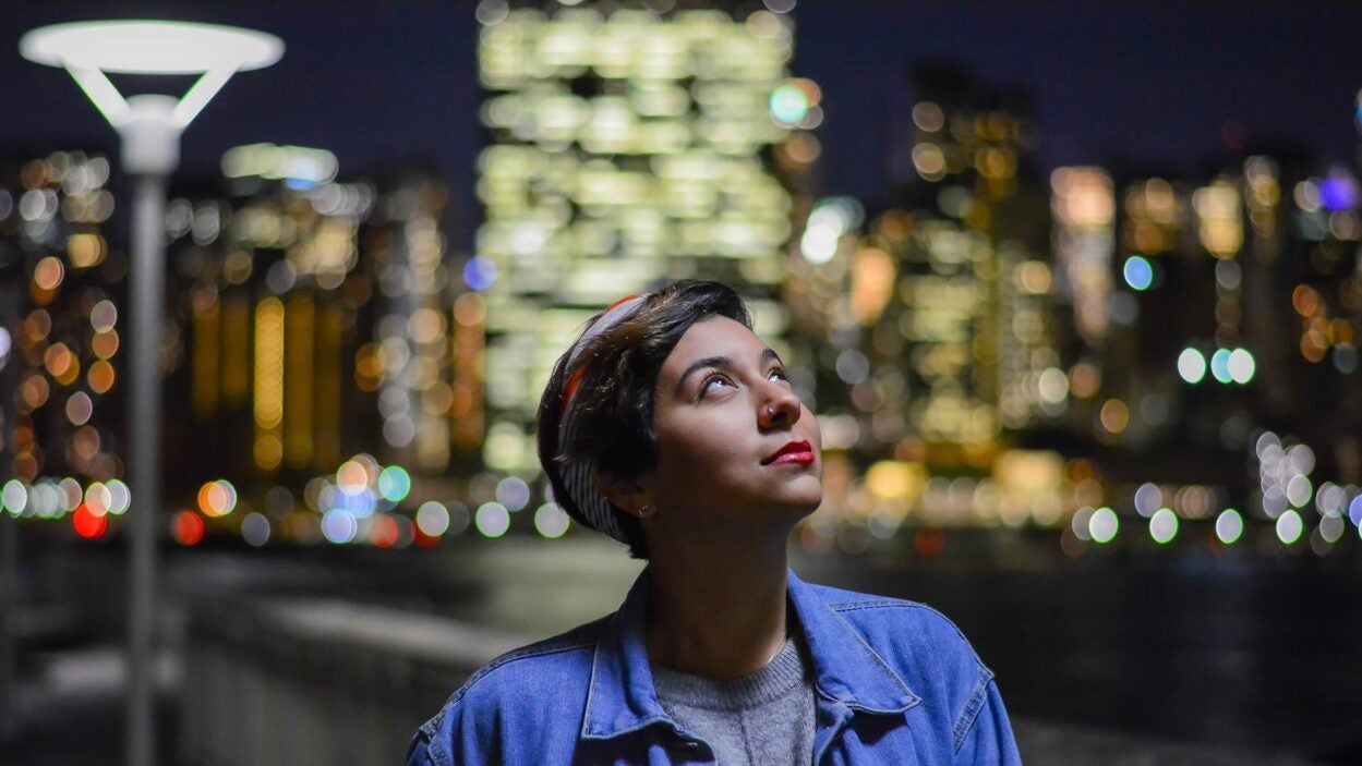 photo of woman looking at the city lights at night