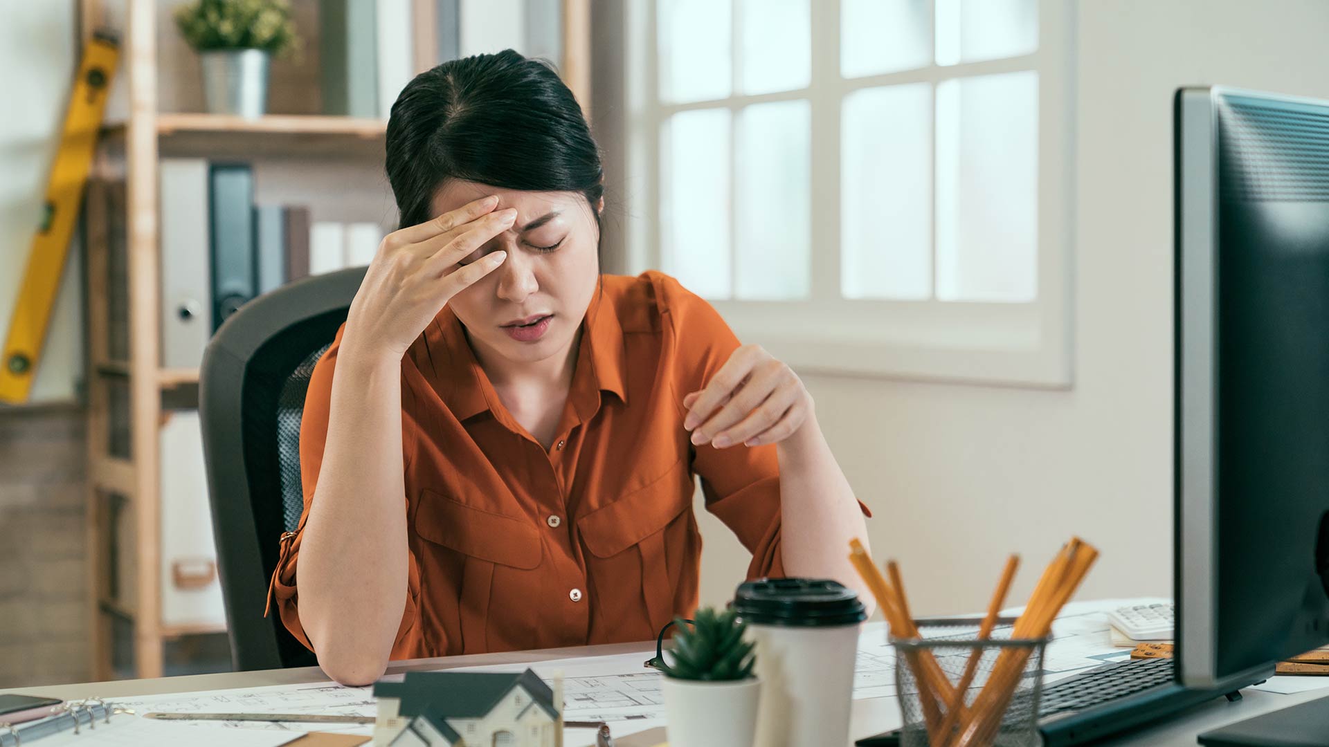 photo of stressed architect having headache while working