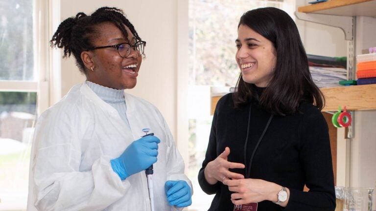 photo of Corina Amor speaking with woman in a lab coat