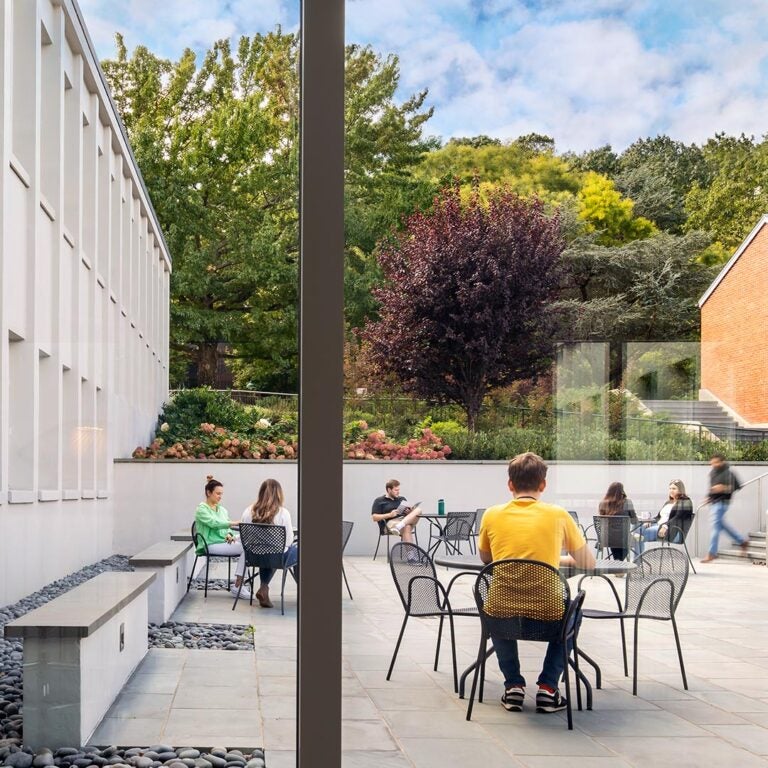 photo of people sitting at tables in the Demerec building patio