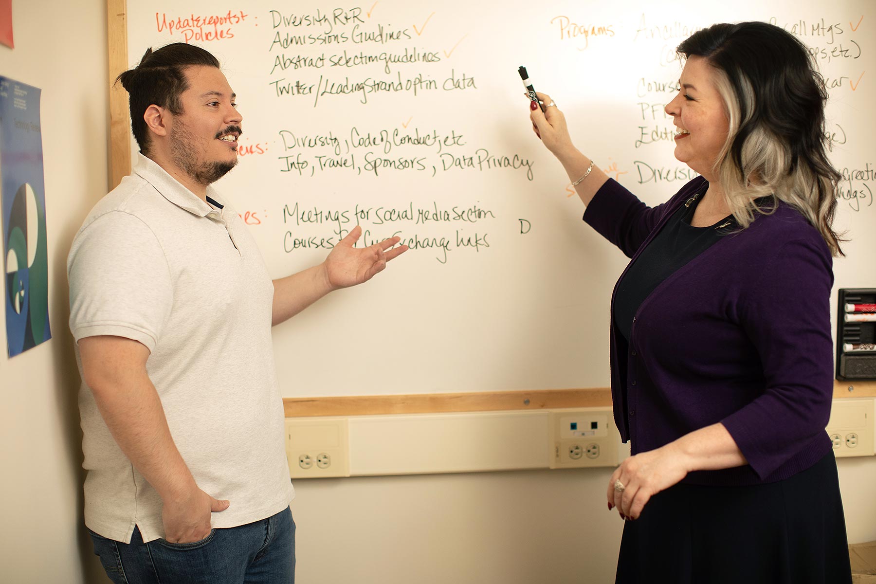 photo of Luis Sandoval and Charla Lambert standing in front of a white board