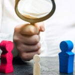 Image of doctor holding magnifying glass over child's toys