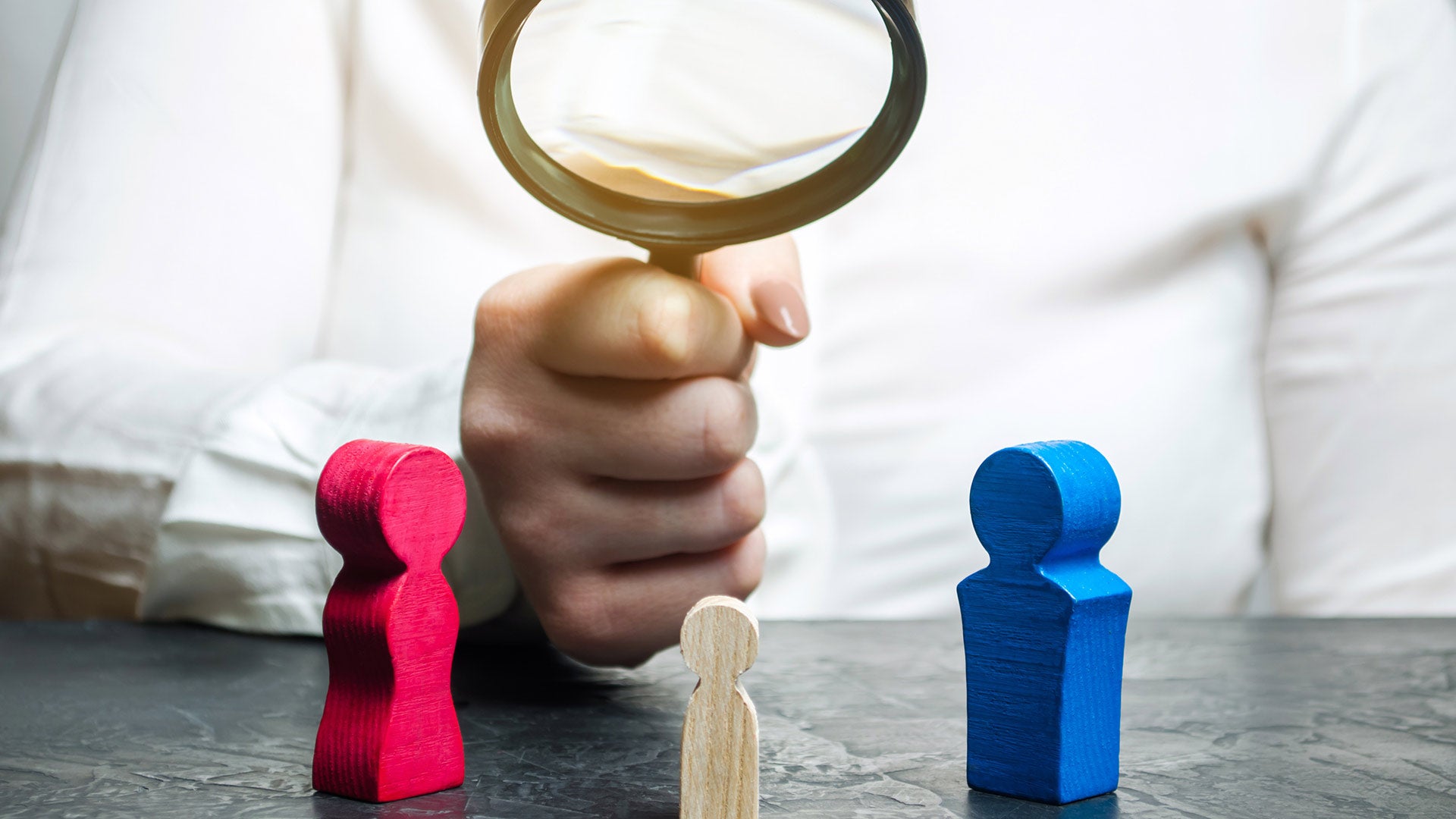 Image of doctor holding magnifying glass over child's toys