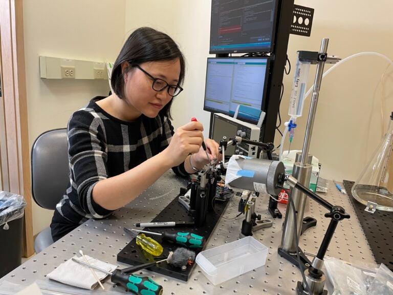 Image of Helen Hou constructing equipment in her lab