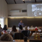 Emmanuel Urquieta Ordonez during his presentation at the December 2022 "Developing an Ethical Framework for Human Research in Private Spaceflight" meeting. He is standing in front of a room of participants.