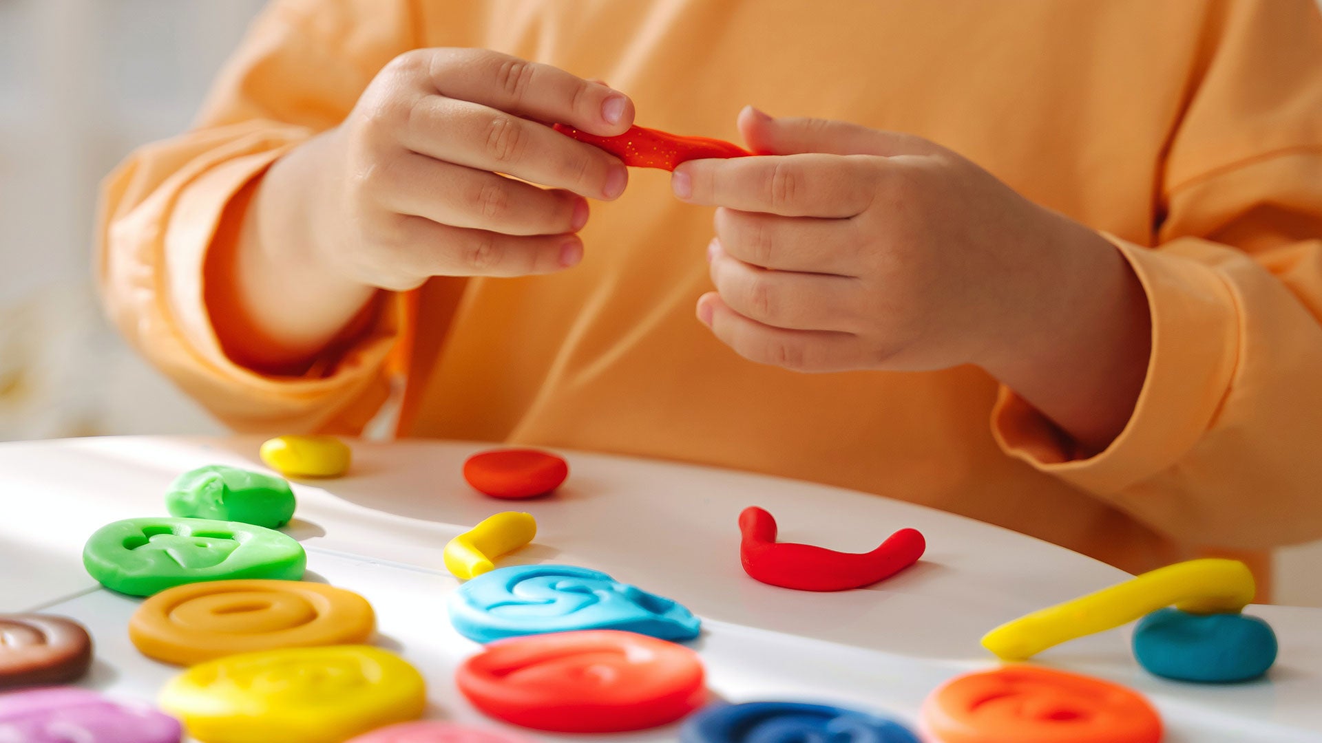 photo of child playing with clay