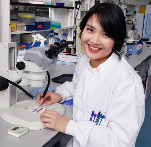 Photo of Viet Hang Le in a white lab coat in a laboratory