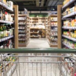 image of the inside of a grocery store with shopping cart in the foreground