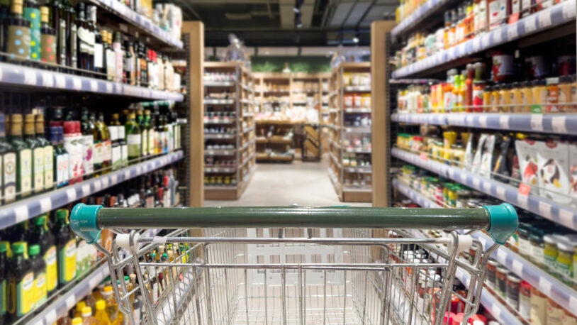 image of the inside of a grocery store with shopping cart in the foreground