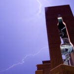 image of the CSHL Hazen Tower with lightning bolts in the background sky