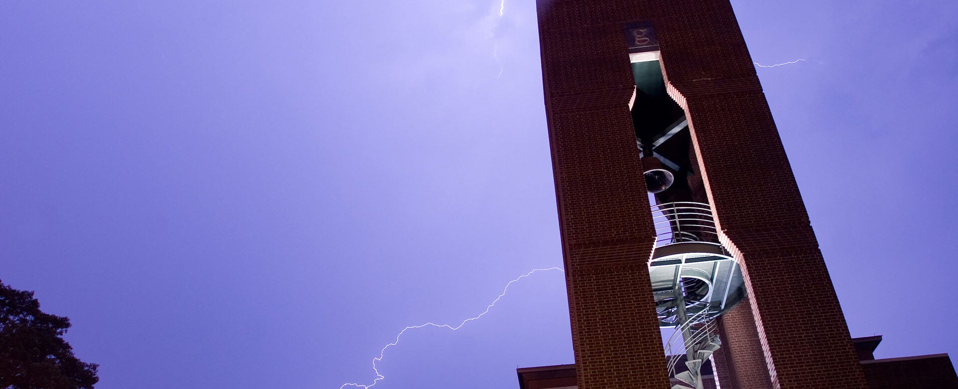 image of the CSHL Hazen Tower with lightning bolts in the background sky