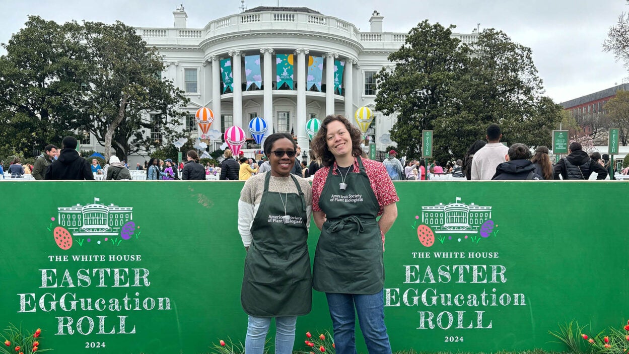 image of CSHL scientists Janeen Braynen and Audrey Fahey standing in front of the White House 2024 Easter EGGucation Roll sign in Washington DC