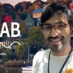 image of Cold Spring Harbor campus from across the harbor with At the Lab podcast logo and portrait of Kyle Daruwalla