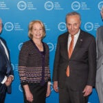 image of CSHL BOTs Casey Cogut and Marilyn Simons, U.S. Senator Chuck Schumer, and CSHL President and CEO Bruce Stillman at the DNA Learning Center, NYC