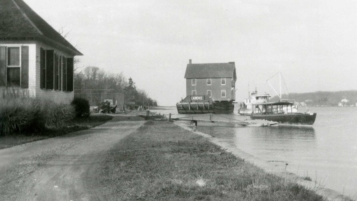 image of the Cold Spring Harbor Village Firehouse moving across the harbor circa 1930s