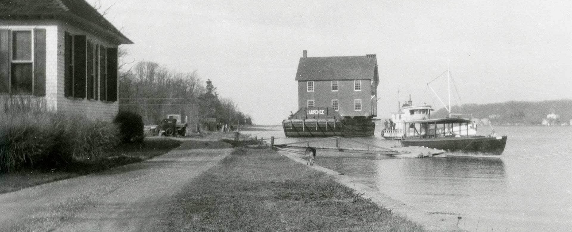 image of the Cold Spring Harbor Village Firehouse moving across the harbor circa 1930s