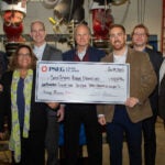 photo of Brandon King presenting CSHL with a check from PSEG