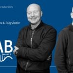 image of the At the Lab podcast logo with black and white portrait of Alexei Koulakov and Tony Zador on a blue background