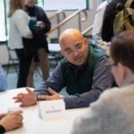 Image of Arkarup Banerjee speaking with graduate students at the 2025 CSHL Innovators Symposium