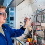 Image of Elliot Smith sketching a formula in the Moses lab