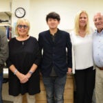 Dr. Lingbo Zhang (middle) with a member of his lab (far left) and the Saladino family from the Monti Foundation standing together in his lab.