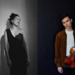 Chaeyoung smiles and Oliver wearing a jacket holds a violin against a dark background.