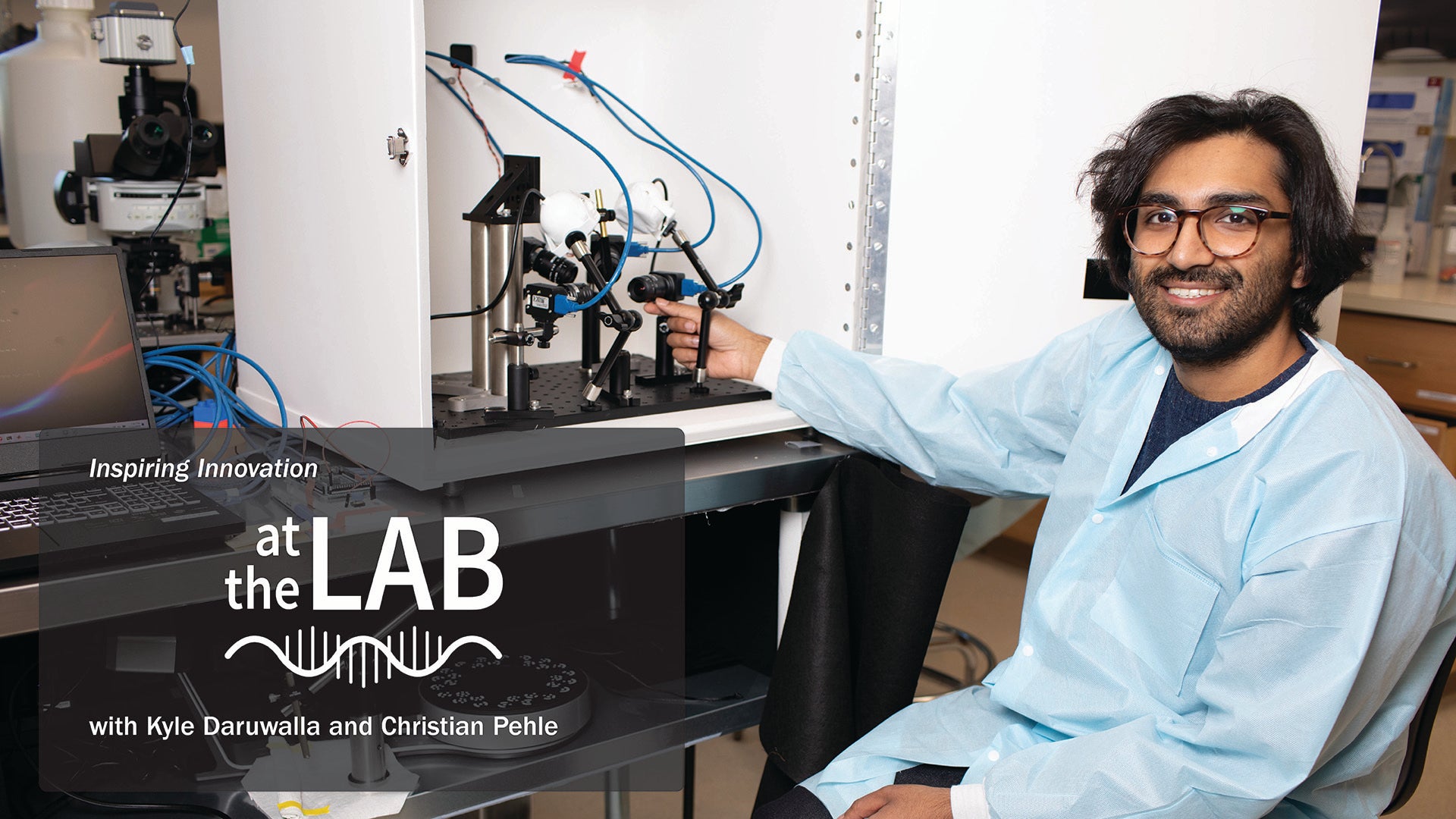 Kyle Daruwalla in a lab coat operates equipment in a laboratory setting with text overlay about a lab show.