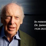 Elderly man outdoors with tribute text: In remembrance of Dr. James D. Watson 1928-2025.
